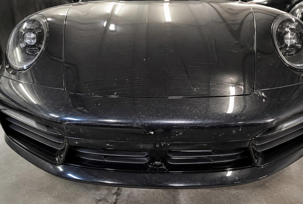 Black Porsche 911 front end with rock chips before paint protection film