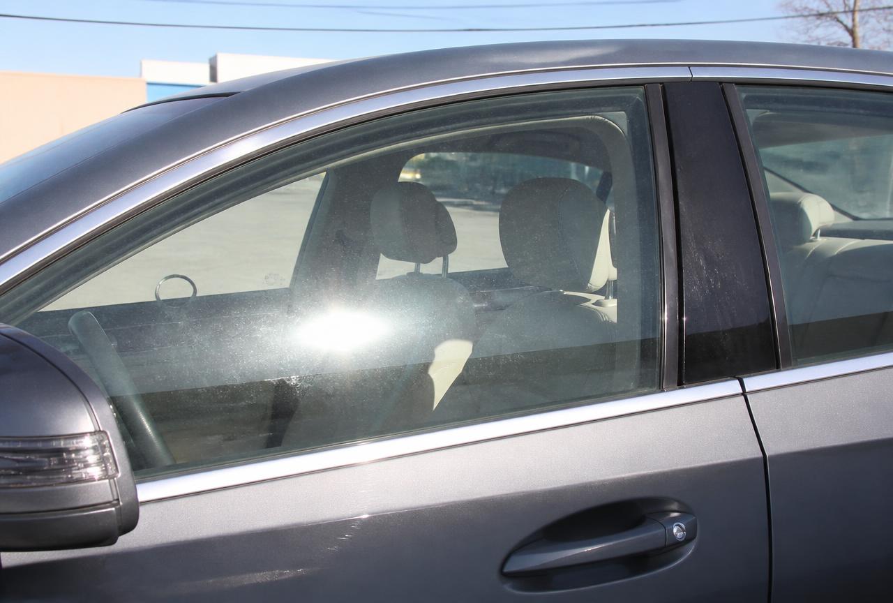 Grey Mercedes-Benz sedan side glass untinted with heavy sun glare